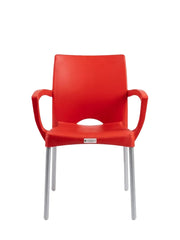 A modern red plastic dining chair with integrated armrests and slim silver metal legs, shown against a plain white background.